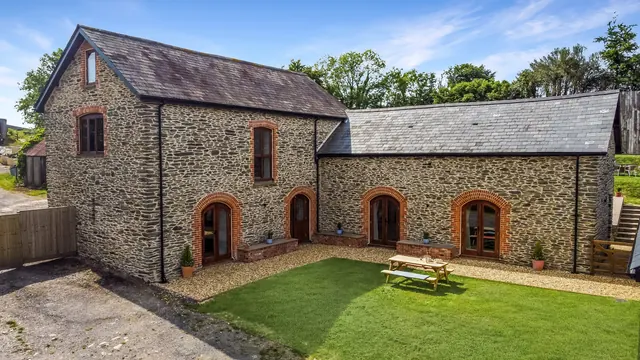 The stone barn across its courtyard lawn, a picnic table by the door